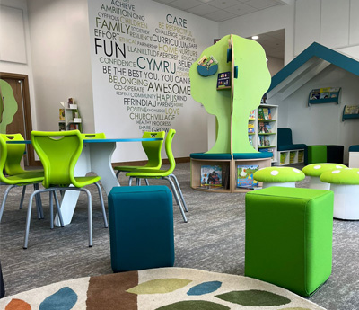 Colorful children's library and reading space in Llaniltud primary school with green and blue furniture